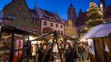Schmalkalden: Gleich zwei mittelalterliche Weihnachtsmärkte  70 Kilometer, Fahrtzeit eine gute Stunde von Erfurt  Sie mögen Märkte mit romantisch mittelalterlicher Atmosphäre? Dann lohnt der Besuch von Schmalkalden gleich doppelt. Im Zentrum der Stadt zwischen liebevoll restaurierten Fachwerkhäusern und steinernen Kemenaten lädt vom 26. 11. bis zum 23. 12. der Herrscheklasmarkt ein. Gemütlich wird es am Abend, wenn zahlreiche Scheinwerfer die Gebäude rund um den Markt in buntes Licht tauchen.  Unweit davon öffnet an den ersten beiden Adventswochenenden der Mittelalterliche Weihnachtsmarkt auf Schloss Wilhelmsburg seine schweren Tore. Im Schlosshof, im Weinkeller und in der Schlossküche lassen sich Töpfer, Imker, Schneider und Zinngießer über die Schulter schauen und geben Einblick in alte Techniken. Und was wäre ein Mittelaltermarkt ohne Ritter? Sie führen täglich die Kunst des Schwertkampfes, aber auch des Schwerttanzes vor.