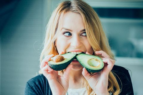 Frau isst Avocado