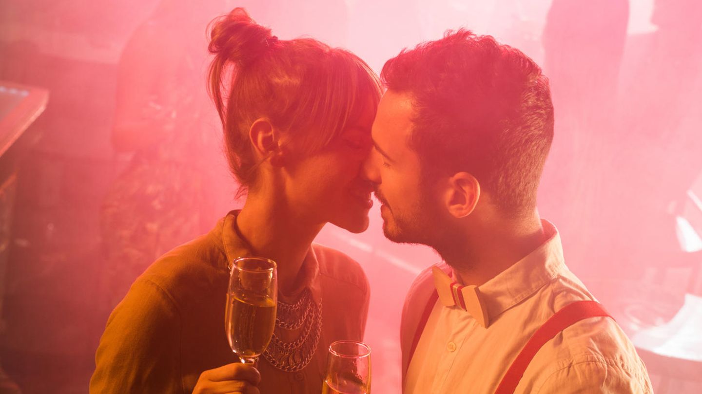 Fremdknutschen: Ein Mann und eine Frau küssen sich in einem Club