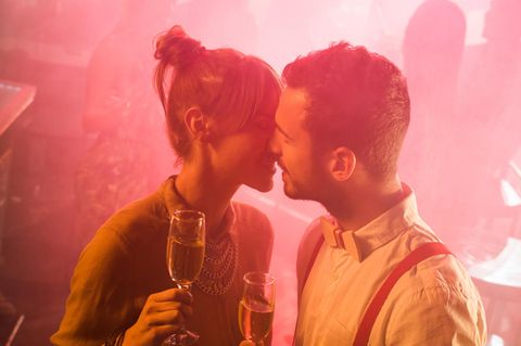 Fremdknutschen: Ein Mann und eine Frau küssen sich in einem Club