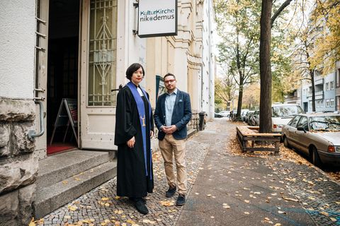 Eine junge Pastorin und ein junger Rabbi stehen vor dem Gebäude der Kulturkirche Nikodemus