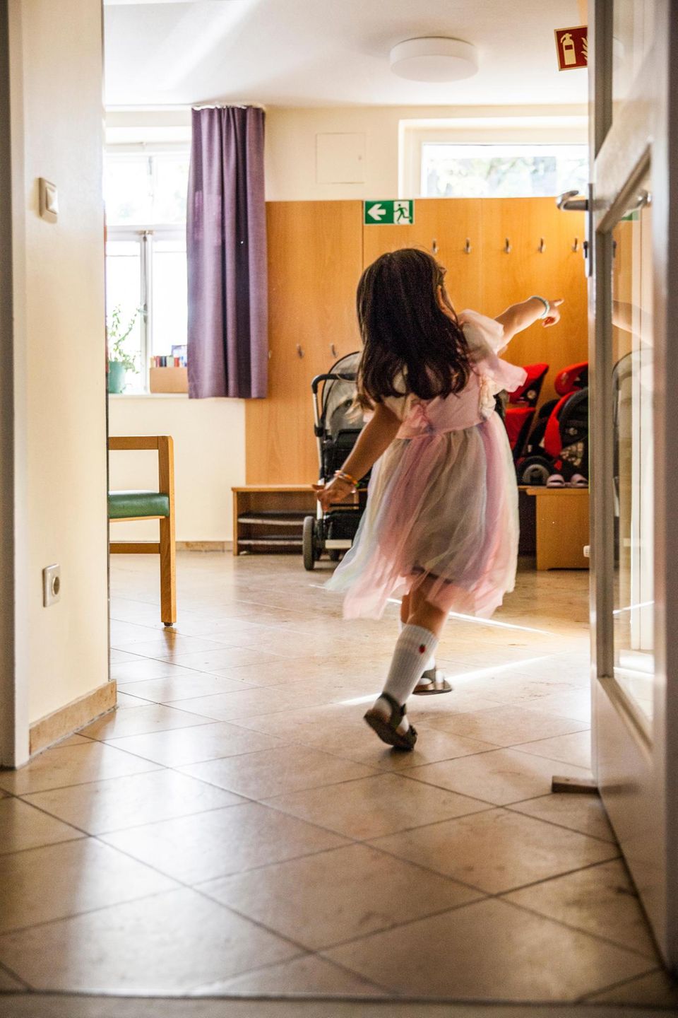 Ein kleines Mädchen im Feenkleid zeigt auf etwas
