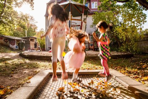 Drei Mädchen springen in der Herbstsonne auf einem Trampolin