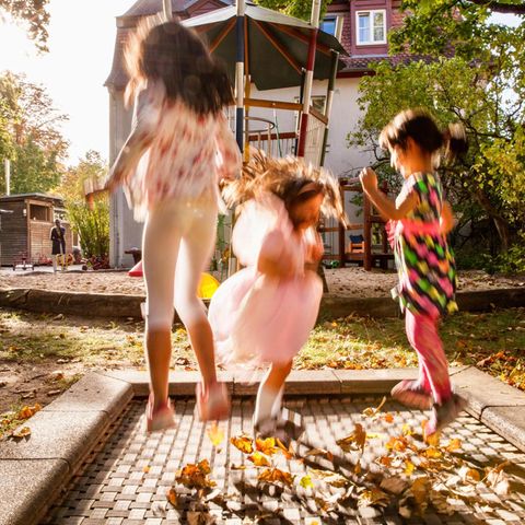 Drei Mädchen springen in der Herbstsonne auf einem Trampolin