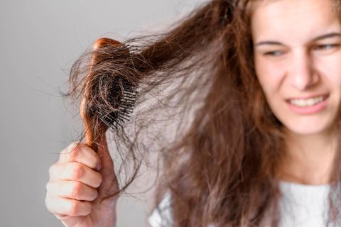 Frau bürstet ihre Haare