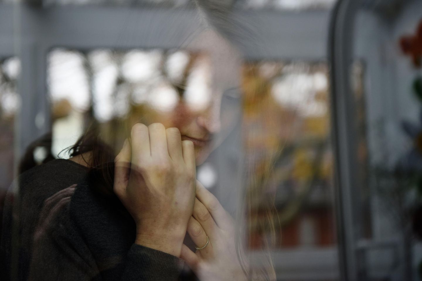 Eine Junge Frau hinter einem Fenster