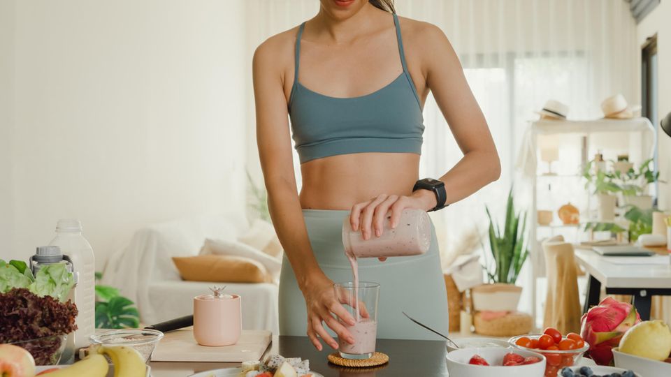 Eine Frau serviert einen Protein Shake zum Abnehmen.