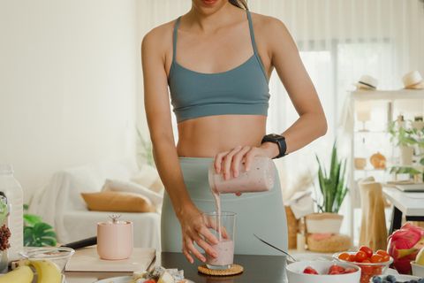 Eine Frau serviert einen Protein Shake zum Abnehmen.
