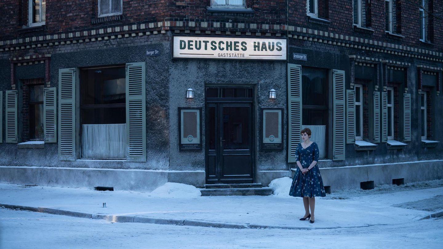 eine junge Frau steht  im Schnee vor einer Gaststätte namens "Deutsches Haus"