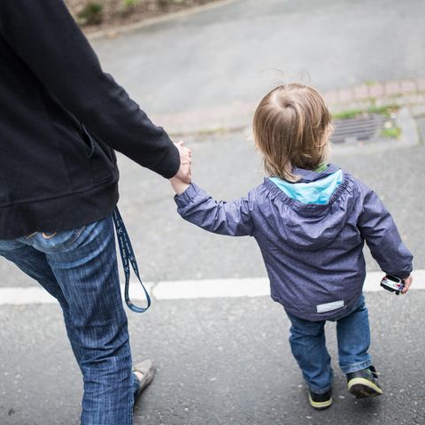 Eine Mutter hält ihren kleinen Sohn an der Hand