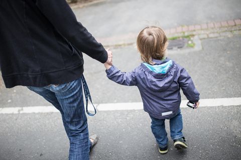 Eine Mutter hält ihren kleinen Sohn an der Hand