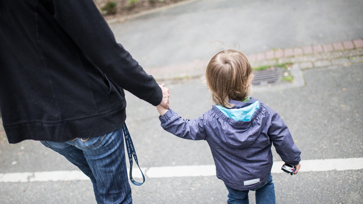 Eine Mutter hält ihren kleinen Sohn an der Hand