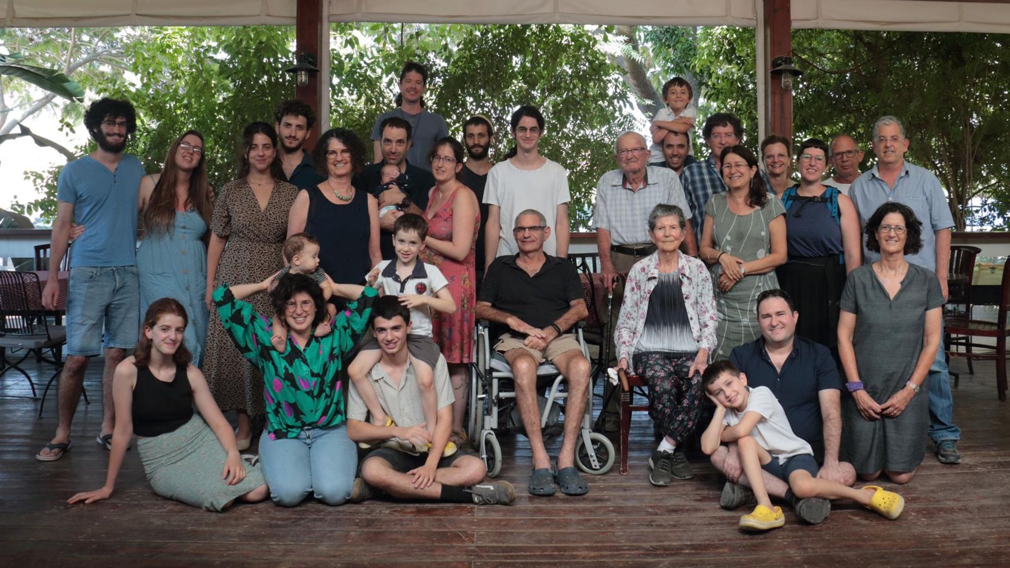 Eine Foto, das eine Großfamilie zeigt: Menschen, die zusammensitzen und stehen