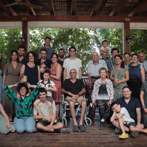 Eine Foto, das eine Großfamilie zeigt: Menschen, die zusammensitzen und stehen