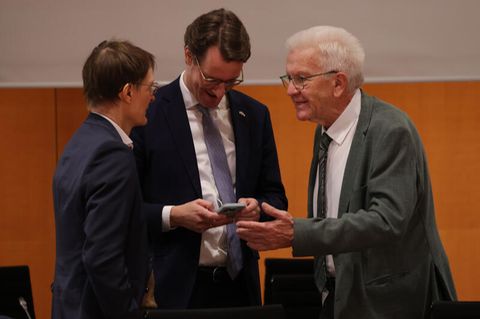 Die Ministerpräsidenten Winfried Kretschmann (Baden-Württemberg) und Hendrik Wüst (NRW) unterhalten sich mit Gesundheitsminister Karl Lauterbach zu Beginn des Bund-Länder-Gipfels im Bundeskanzleramt