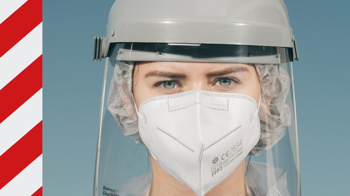 Frau mit FFP2-Maske und Schutzschild