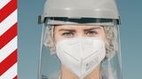 Frau mit FFP2-Maske und Schutzschild
