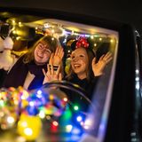 Zwei junge Frauen im Karnevals-Ausfit feiern im Auto