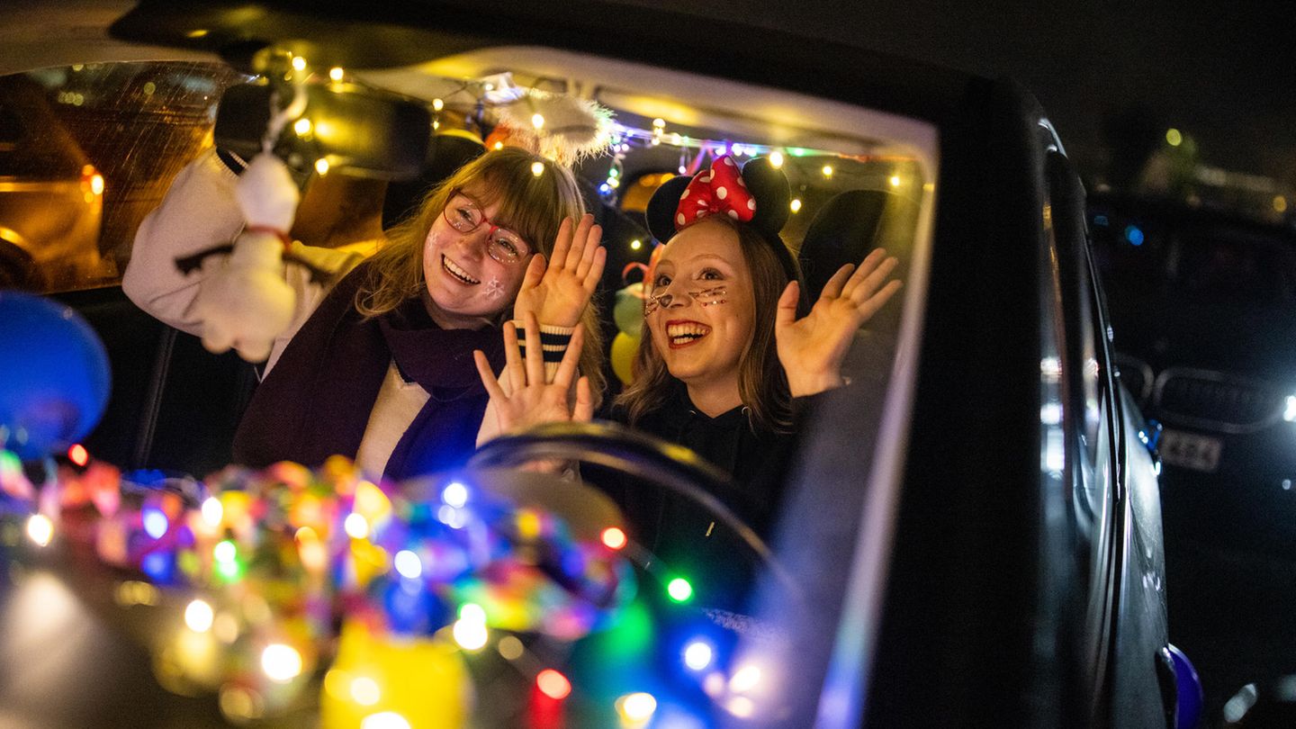 Zwei junge Frauen im Karnevals-Ausfit feiern im Auto