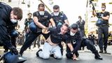 Mann am Boden umgeben von mehreren Polizisten