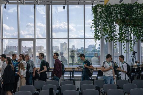 Junge Menschen stehen in einer Schlange in einem modernen Gebäude