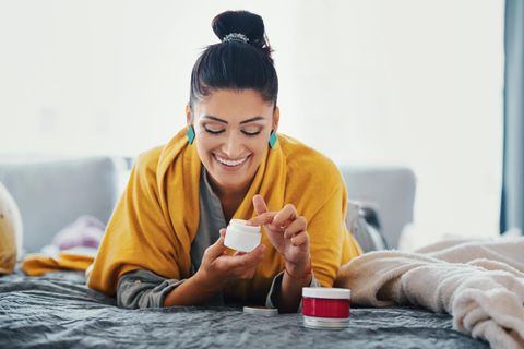 Frau pflegt ihre Haut mit einer Creme