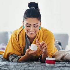 Frau pflegt ihre Haut mit einer Creme