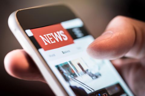 Medienkonsum: Ein Mann hält ein Smartphone in der Hand und liest Nachrichten