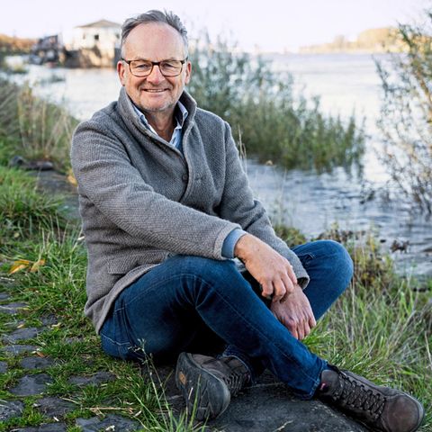 Portrait Frank Plasberg sitzt am Rheinufer