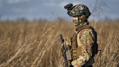 Ein Soldat im Süden der Ukraine läuft mit Gewehr in der Hand