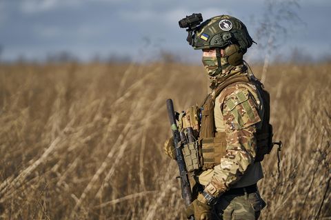 Ein Soldat im Süden der Ukraine läuft mit Gewehr in der Hand