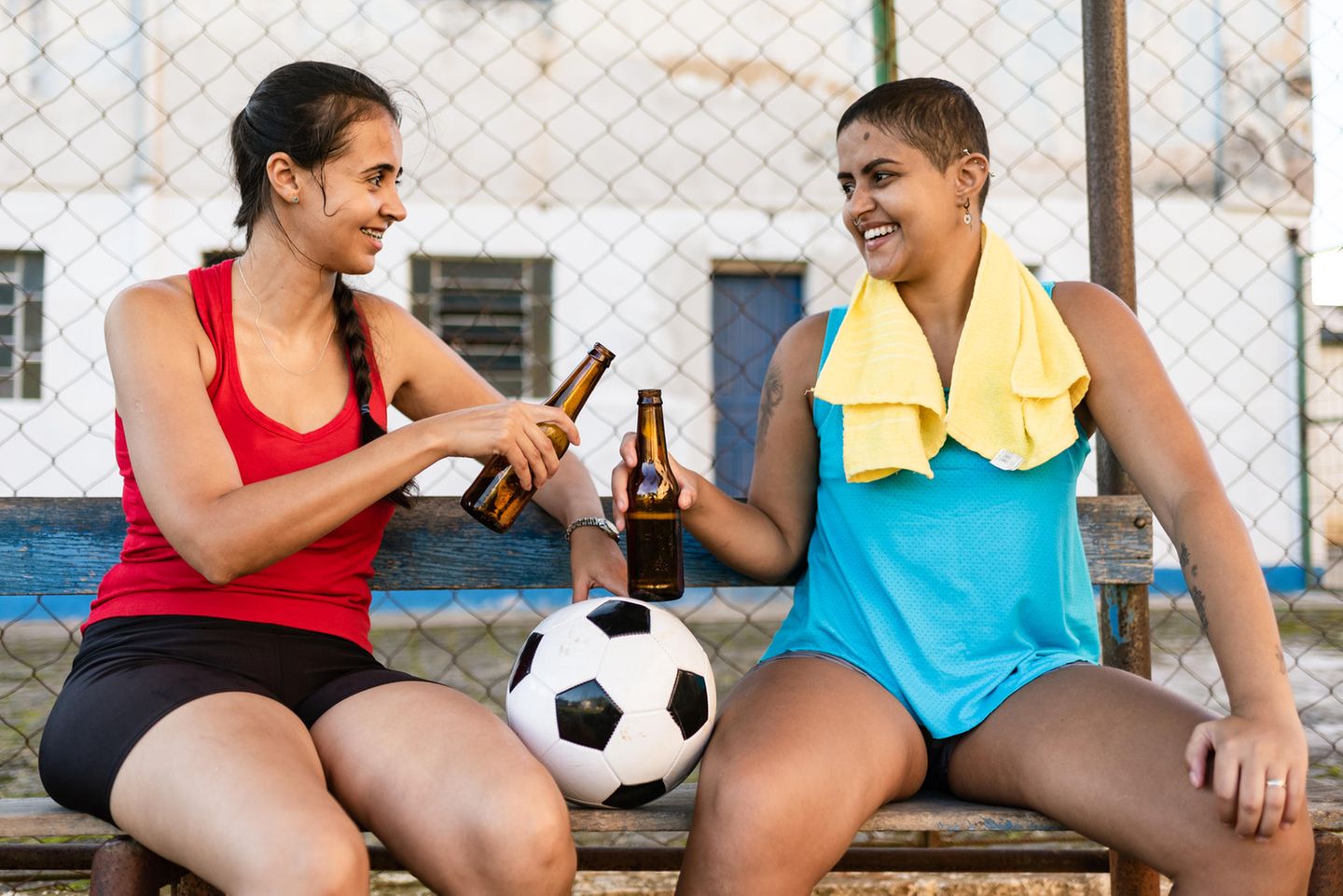 zwei Frauen stoßen mit Flaschen an zwei Frauen stoßen mit Flaschen an