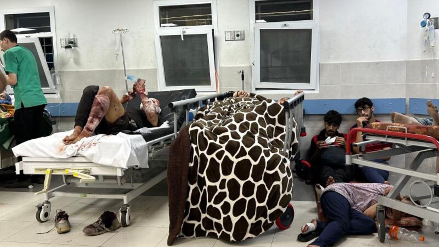 Auch auf dieser Station sieht es nicht besser aus. Ein schwerverletzter Patient liegt mit blutigen Verbänden im Bett, andere haben sich auf dem Boden zusammengekauert.