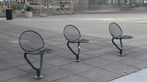 Einzelne Stühle stehen an einem öffentlichen Platz