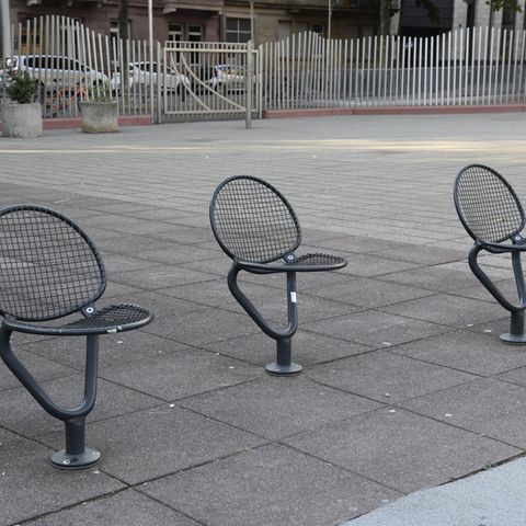 Einzelne Stühle stehen an einem öffentlichen Platz