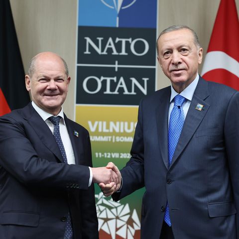 Olaf Scholz und Erdogan geben sich die Hand und schauen in die Kamera