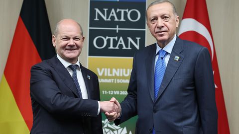 Olaf Scholz und Erdogan geben sich die Hand und schauen in die Kamera