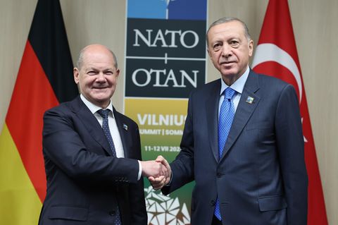 Olaf Scholz und Erdogan geben sich die Hand und schauen in die Kamera