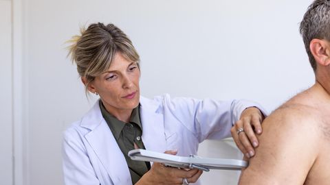 Eine Ärztin kontrolliert den Körperfettanteil ihres Patienten