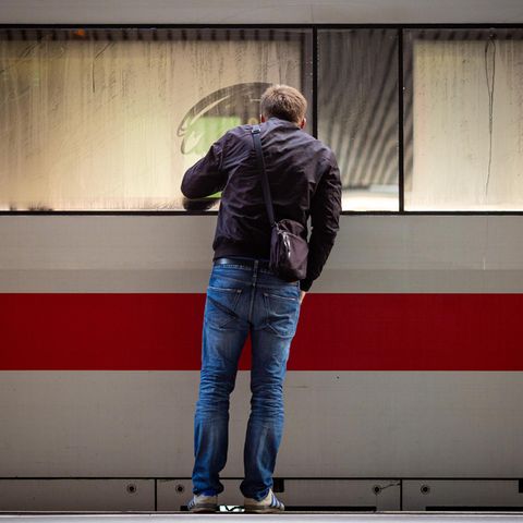Ein Mann schaut in einen am Bahnsteig stehenden ICE