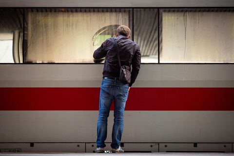 Ein Mann schaut in einen am Bahnsteig stehenden ICE