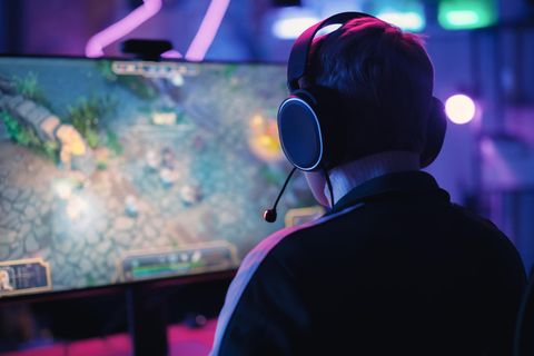 Black Friday Gaming-PC: Eine Frau sitzt freudig an einem Computer und zockt