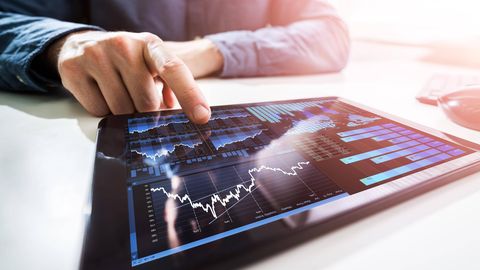 Ein Mann beobachtet die Aktienkurse auf dem Tablet