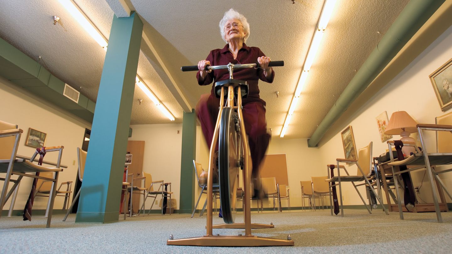Eine alte Dame trainiert auf einem Trainingsrad