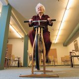 Eine alte Dame trainiert auf einem Trainingsrad