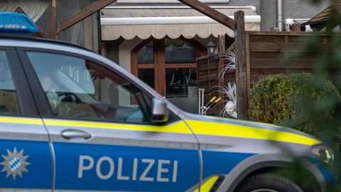 Ein Auto der Polizei Bayern steht vor einem Lokal