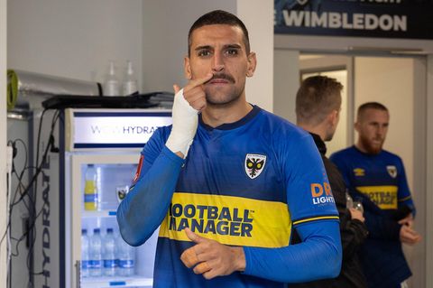 Mann mit blauem Trikot und schwarzem Schnauzbart