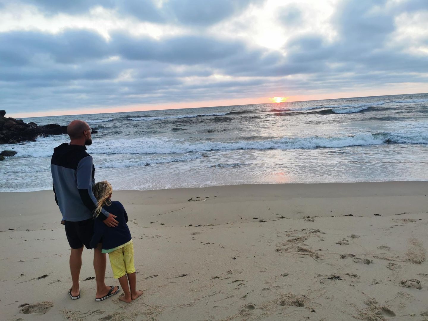 Vater Max und Sohn Phileas blicken am Strand aufs Meer