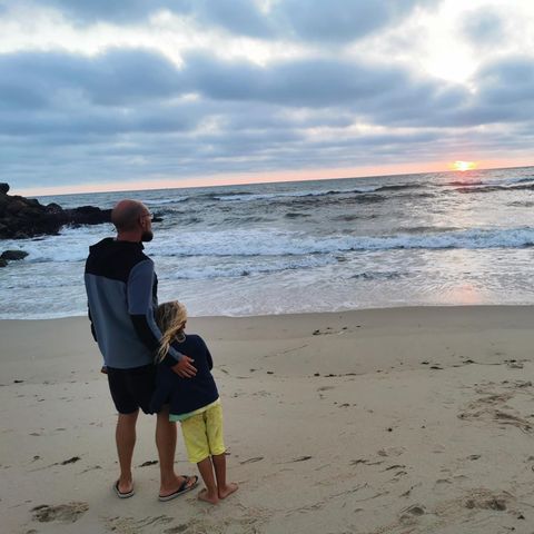Vater Max und Sohn Phileas blicken am Strand aufs Meer