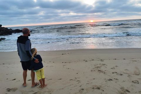 Vater Max und Sohn Phileas blicken am Strand aufs Meer